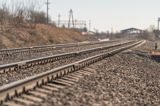 Parallel tracks highlighting freight transportation methods. Multiple railway tracks running through freight zone with industrial buildings nearby and supporting utility poles