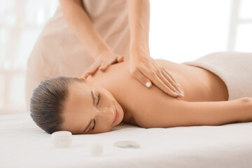 Obraz premium Young woman getting massage by therapist in spa salon