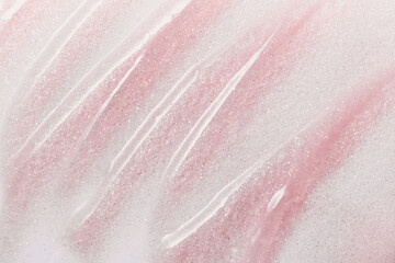 Fototapeta premium Pink glitter background with cosmetic streaks creating an abstract texture
