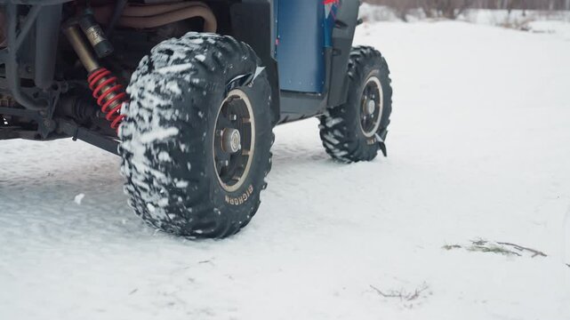 Snow and ice challenge rider skillfully navigating ATV through snowy landscape. Motorcycle performer skillfully performs sharp turns with spray of snow and skid marks on icy terrain