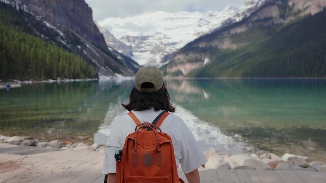 Woman hiker admiring Lake Louise in Banff National Park, Canada