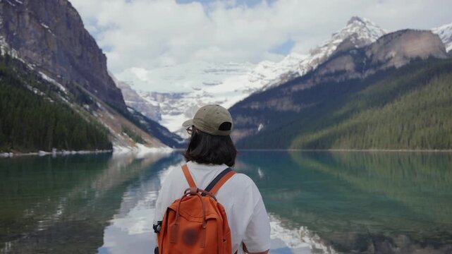 Woman hiker admiring Lake Louise in Banff National Park, Canada