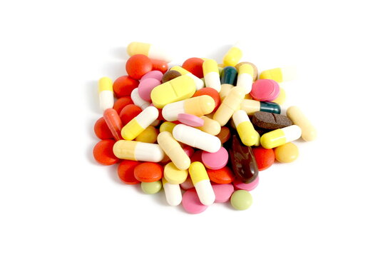 There is a pile of brightly colored pills on a white background.