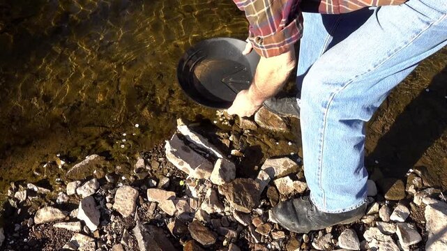 Swirling water in a gold pan, creekside.