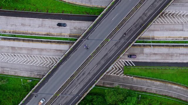 High-angle drone shot of multi-level asphalt road junction featuring smooth traffic flow