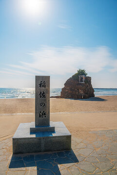 稲佐の浜の石碑と弁天島が広がる海辺の風景