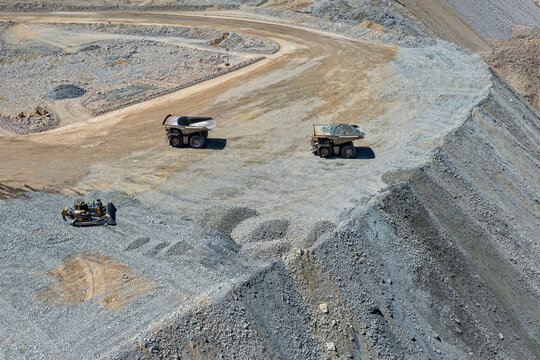 Panoramic view of mining dump trucks unloading waste material at a mine dump