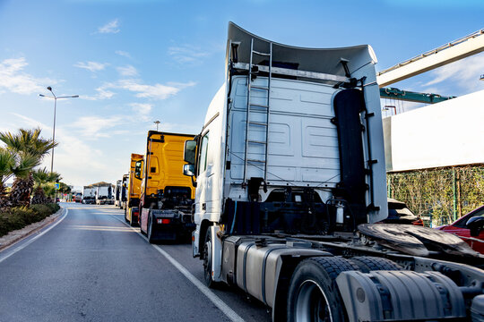 Long queue of commercial trucks waiting in line on a highway