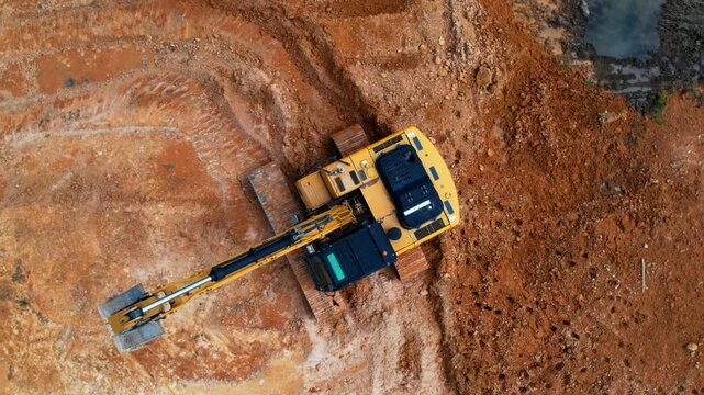 Rotating overhead view of excavator in construction site.