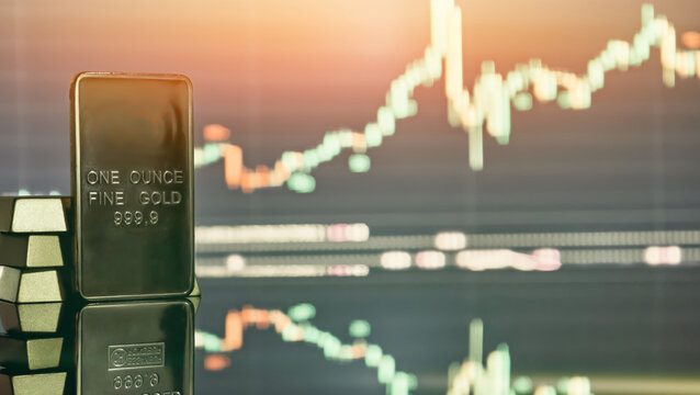 one ounce gold bar and trading chart. Concept of gold investment, commodities market and inflation protection.