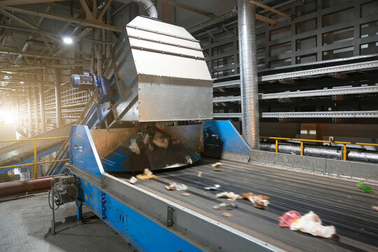 Line with municipal waste on a conveyor belt in Waste energy plant, high-speed optical converter screener. Recycling, sustainable energy, waste management, environmental protection.