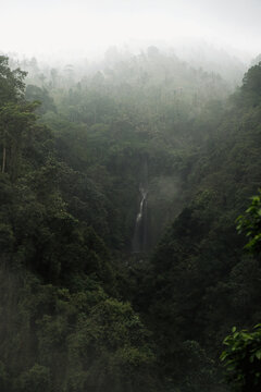 Multiple waterfalls cascading over mossy rocks at Sekumpul, Bali