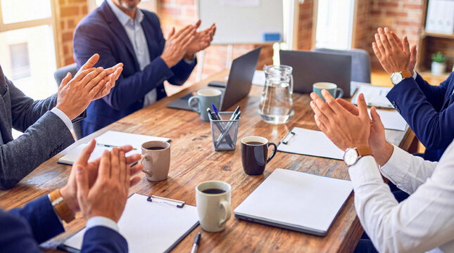 Diverse business team applauding success at a corporate meeting. Professionals clapping hands during a presentation.