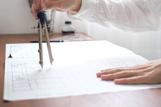 建築士が製図作業を行う手元　コンパスを使った建築設計図の作成 An architect working on a drawing