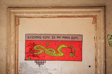 Colorful mural reading “Kissing You Is My Main Aim” inside abandoned Sanatorium Iveria, Tskaltubo, Georgia. © Pernelle Voyage