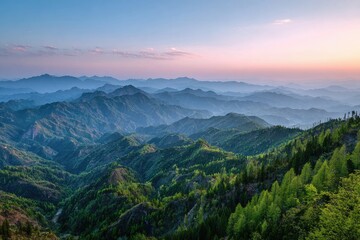 Fototapeta premium Lush, green mountain landscape receding into misty blue and pink twilight sky
