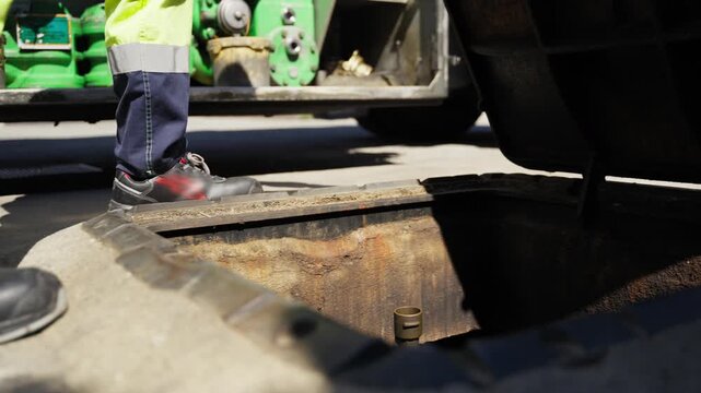 Workers hands open airport tank manhole for refueling plane