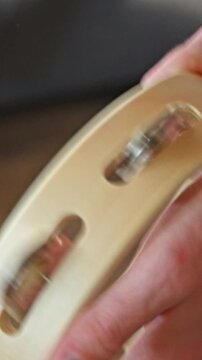 Slow Motion Close-up of Hand Shaking Wooden Tambourine