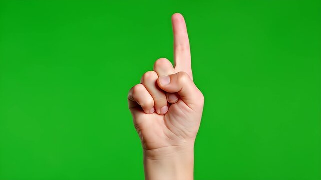 Human hand pointing index finger upwards on a green background