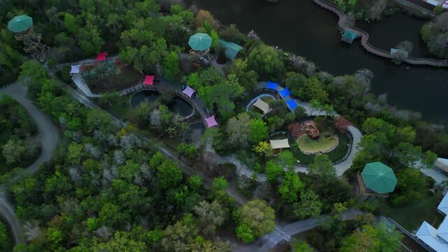 Top down drone view of theme park with paths water channels and canopy