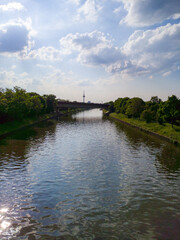 Fototapeta premium Serene river landscape with bridge and distant tower