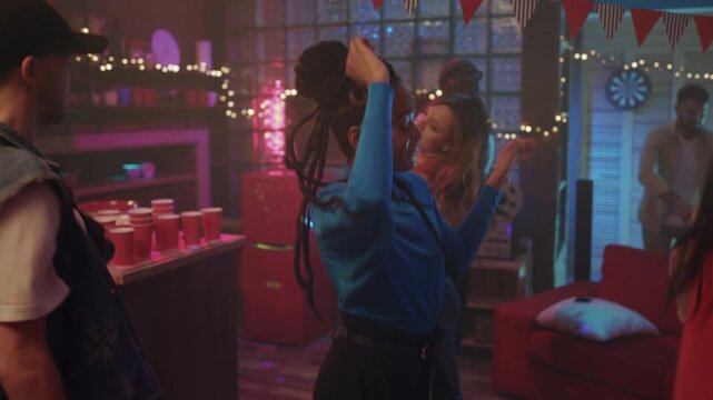 Youthful woman enjoying lively dance, Teenage girl twirling amid friends during energetic nighttime celebration