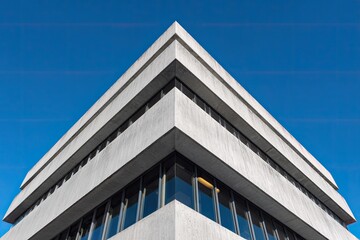 Obraz premium Modern Office Building Corner Against Clear Blue Sky.