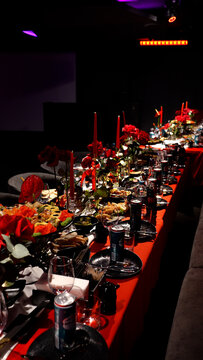 Decorated red themed celebration table for special event, elegant dinner setup with festive decoration, luxury party or birthday concept, warm atmosphere.
