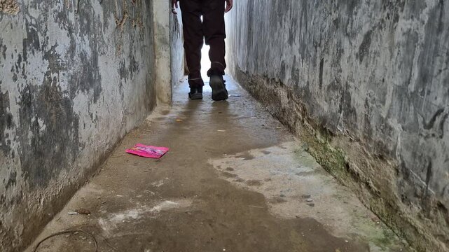 A boy student Walking Through a Narrow Dark Alley Towards the Bright Light