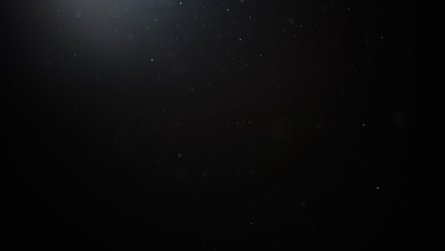dust particles floating mid air over dark background