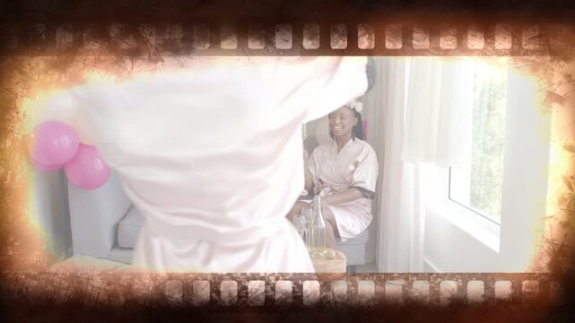 Four women clinking flutes and laughing, newcomer arranging flutes on coffee table, bridal party