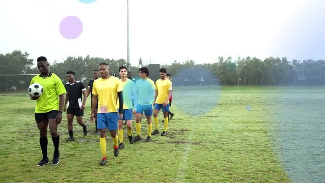 Soccer players warming up across pitch led by green leader carrying ball, colored circles expanding