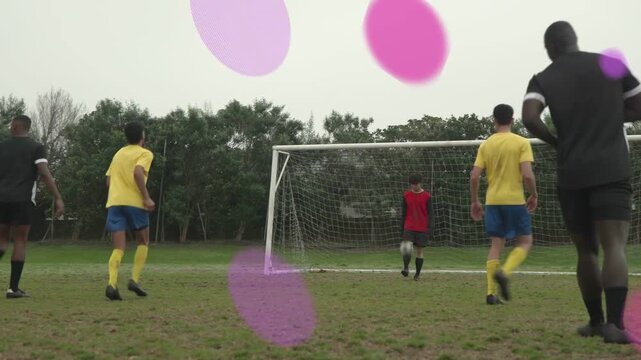 Soccer player in black holding ball near box, dribbling to score while purple rings overlaying net