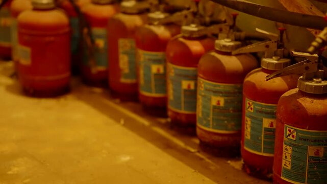Row Of Old Fire Extinguishers In Dusty Storage Room. Expired Fire Extinguishing  In Industrial Basement
