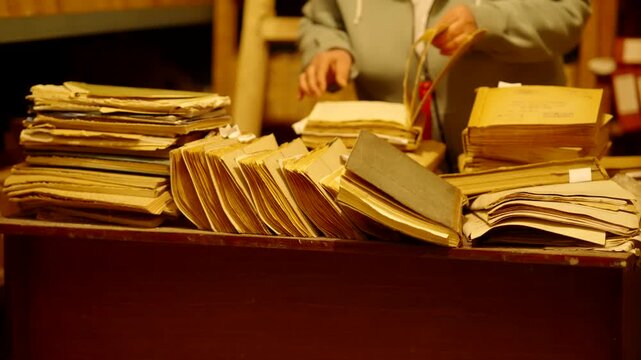Archivist Flipping Through Stacks Of Old Folders. Repository Of Old Documents For Research