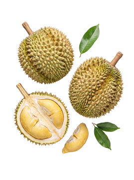 Top-down view of two whole and one halved durian with vibrant green leaves, showcasing creamy yellow flesh.
