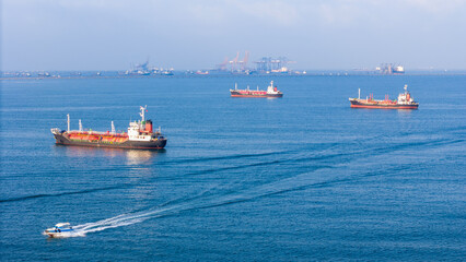 Naklejka na ściany i meble LPG gas and oil tanker ships anchored in the ocean, with a fast patrol boat in the foreground. Global energy transport, war energy crisis, and Strait of Hormuz blockade concept.
