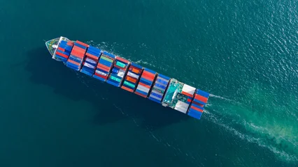Fototapete Segeln large cargo container ship fully loaded with colorful containers sailing through the deep blue ocean. Global maritime trade, freight transport and logistics business.  © Yellow Boat