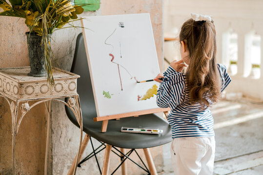 young girl painting on canvas