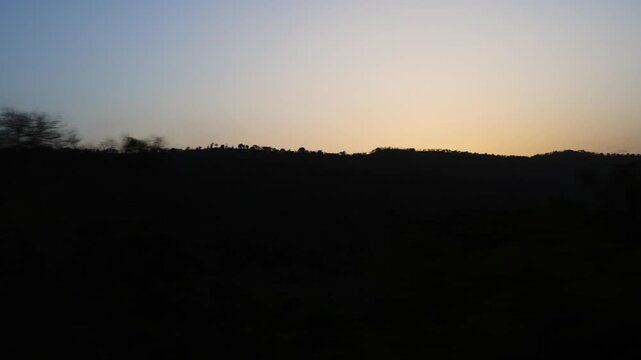 peaceful sunset scene with silhouetted hills and gradient sky colors from konkan railway