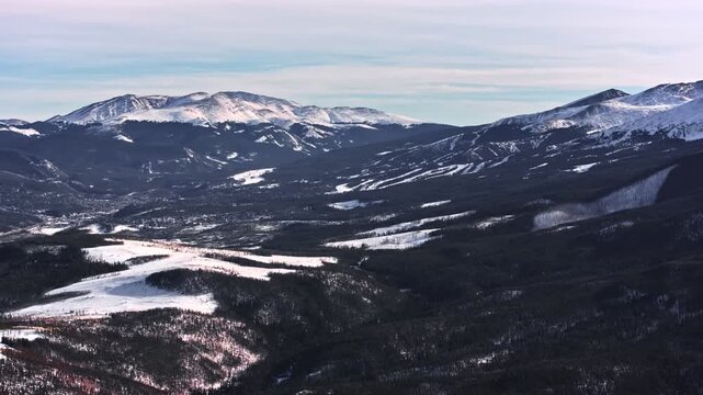 A cinematic, high-flying wide-angle aerial drone shot of snowy peaks surrounding Dillon and Frisco near Breckenridge in Colorado's Rocky Mountains.
