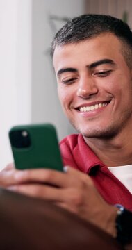 Reading, laughing and man with mobile in home, funny online conversation and internet meme for texting. Message app, social media and happy person with phone for comedy video, browsing and connection