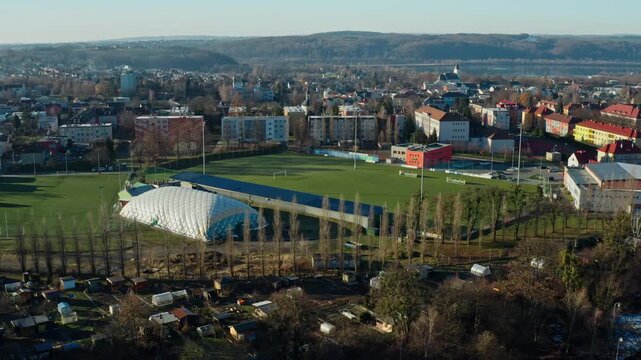 Aerial drone shot around football stadium with hlucin city in background