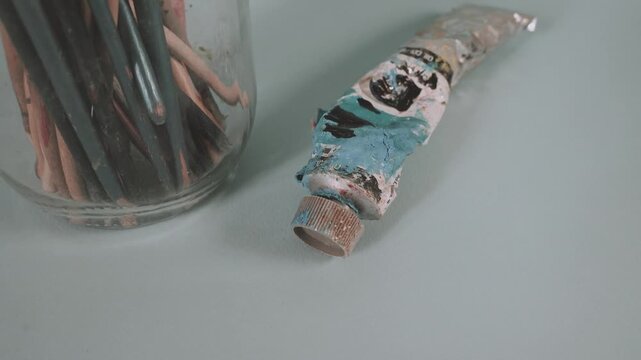 Old paint brushes with a tube of paint, vintage 80's color style                               
