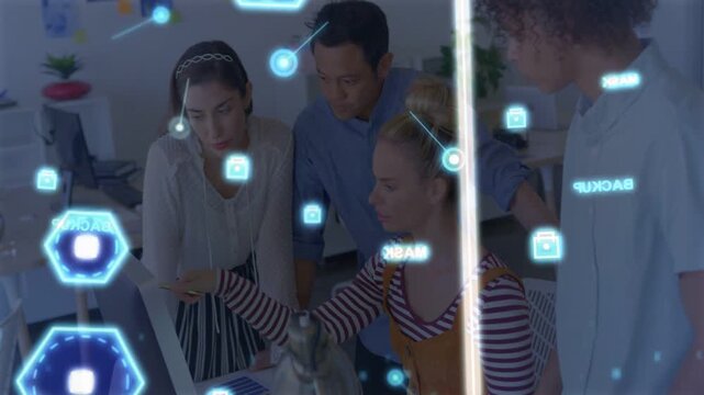 Seated woman pointing at monitor, activating AR icons while colleagues leaning in, reviewing design