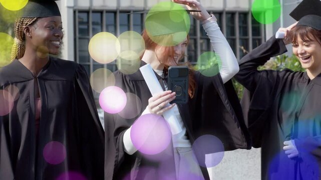 Red-haired grad raising phone and tapping, drawing peers, bokeh fading, showing diploma, graduation