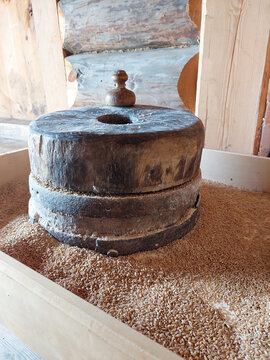 Ancient stone millstones for grinding wheat grain in a wooden barn