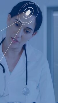 Vertical video: Female doctor reading blue clipboard and activating HUD, tilting head for diagnosis