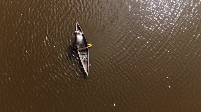 Aerial top view of a traditional fisherman in a wooden boat with his catch in Luanda, Angola