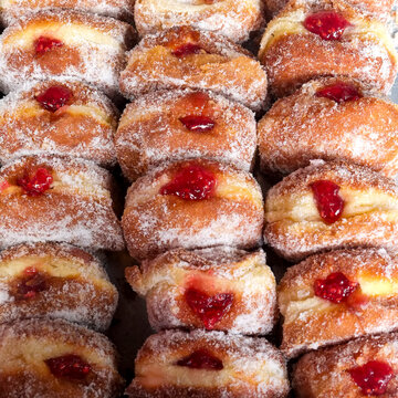 Sugar coated jelly donuts arranged in rows